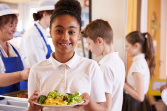 Photo of a young person holding a plate of food