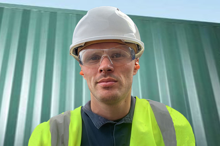 Photo of a person in a high visibility jacket with a hard hat and glasses